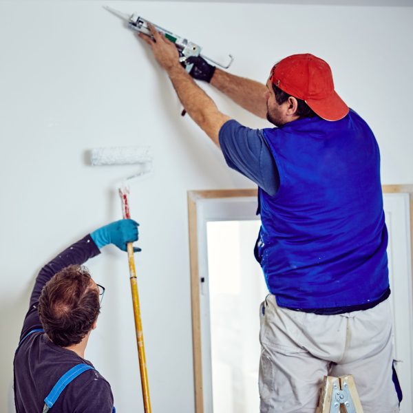 construction-workers-repairing-wall-indoors-during-2026-04-13-02-32-16-utc